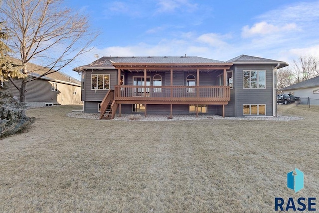 rear view of property featuring a wooden deck and a lawn