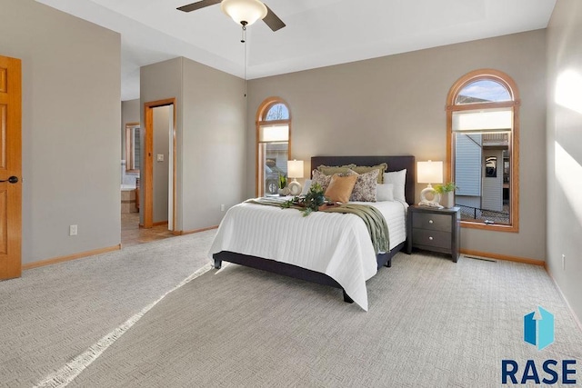 carpeted bedroom with ceiling fan and a tray ceiling