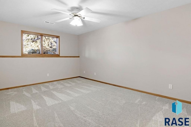 spare room with ceiling fan and light carpet