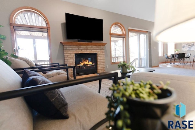 living room featuring a brick fireplace and plenty of natural light