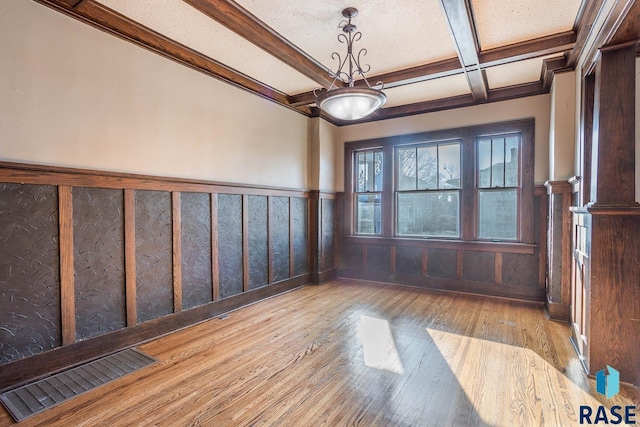 spare room featuring coffered ceiling, beam ceiling, and light wood-type flooring