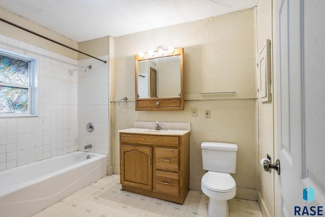 full bathroom featuring vanity, tiled shower / bath, a textured ceiling, and toilet