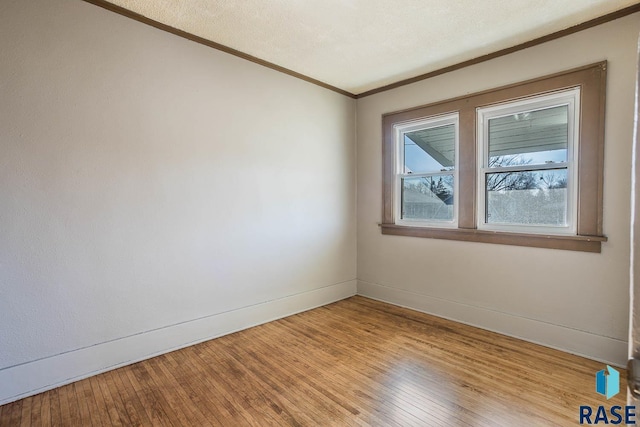 unfurnished room featuring ornamental molding, a textured ceiling, and light wood-type flooring