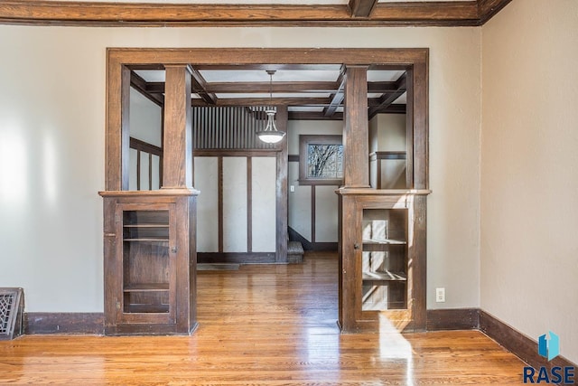 interior space featuring hardwood / wood-style flooring, coffered ceiling, and beam ceiling