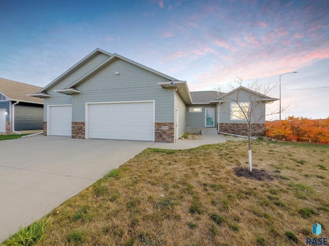 view of front of house with a garage and a lawn