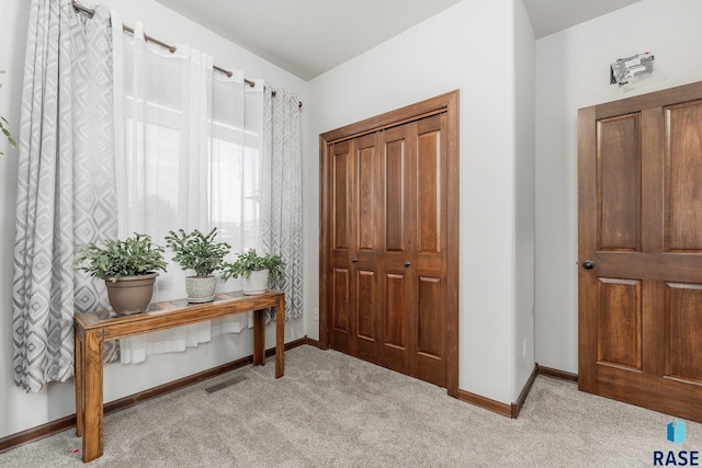 foyer entrance with light colored carpet