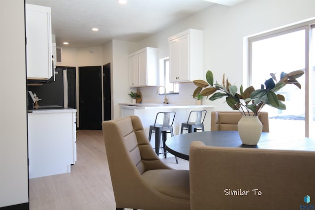 dining area with plenty of natural light, sink, and light hardwood / wood-style floors