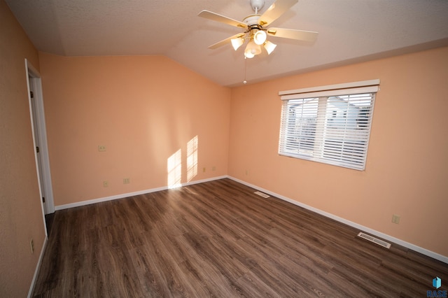 spare room with vaulted ceiling, dark hardwood / wood-style floors, and ceiling fan