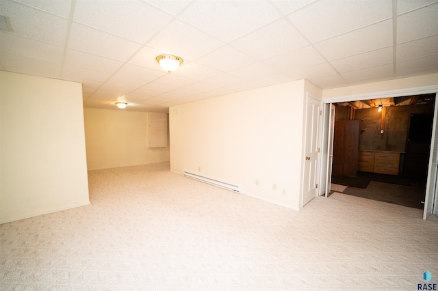 basement featuring a baseboard radiator, carpet, and a paneled ceiling