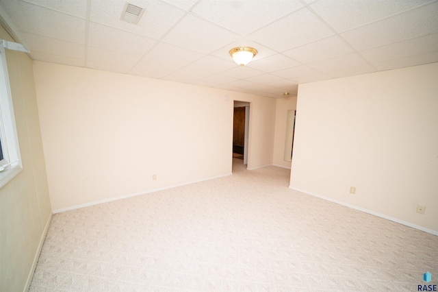 carpeted empty room with a drop ceiling