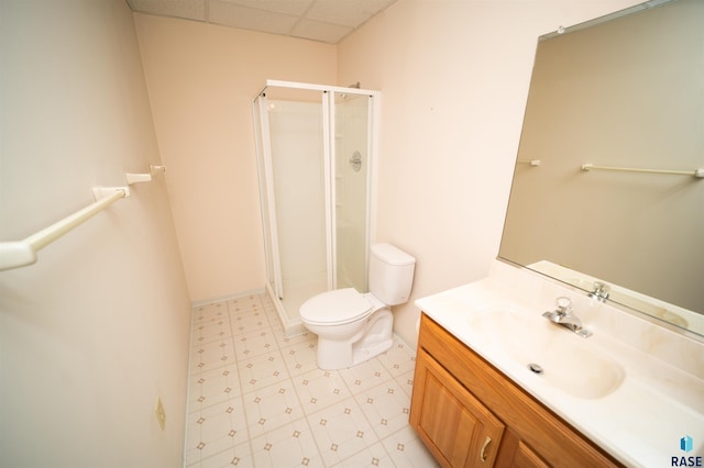 bathroom featuring vanity, a shower with shower door, toilet, and a paneled ceiling