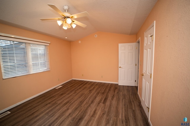 spare room featuring lofted ceiling, dark hardwood / wood-style floors, a textured ceiling, and ceiling fan