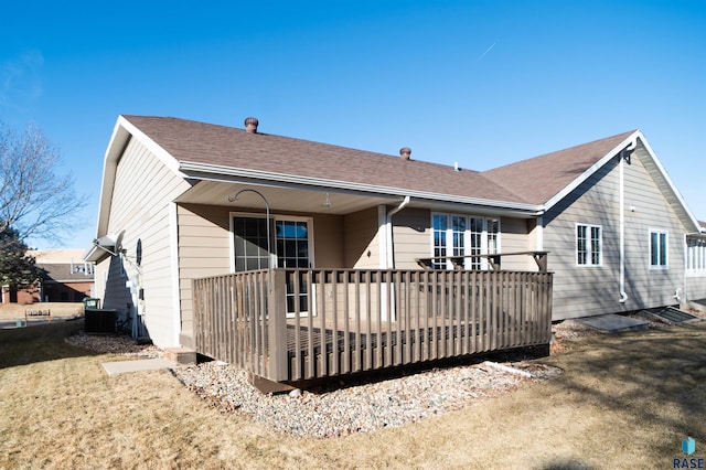 rear view of house featuring a lawn and central air condition unit