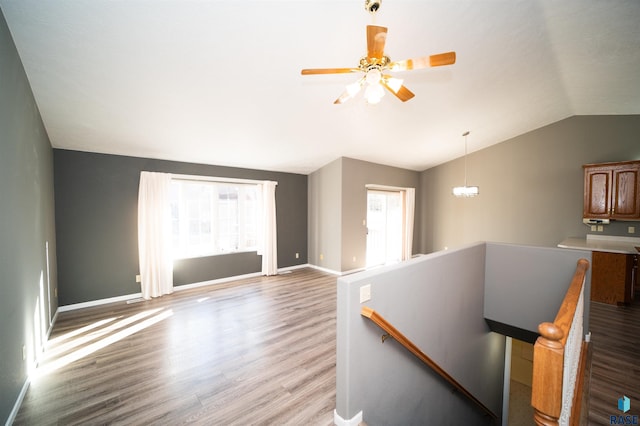 interior space featuring lofted ceiling, hardwood / wood-style floors, and ceiling fan with notable chandelier