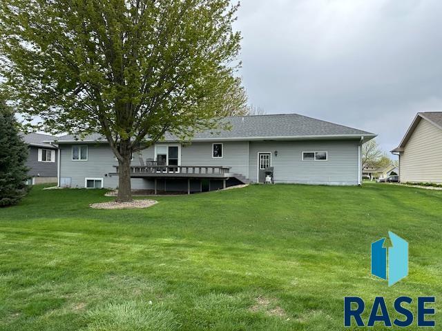 back of house with a wooden deck and a yard