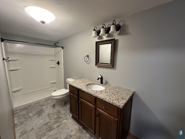 bathroom featuring vanity, walk in shower, and toilet