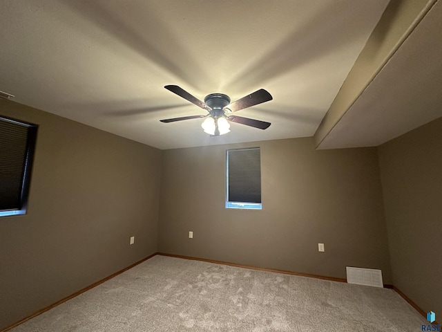 empty room featuring ceiling fan and carpet