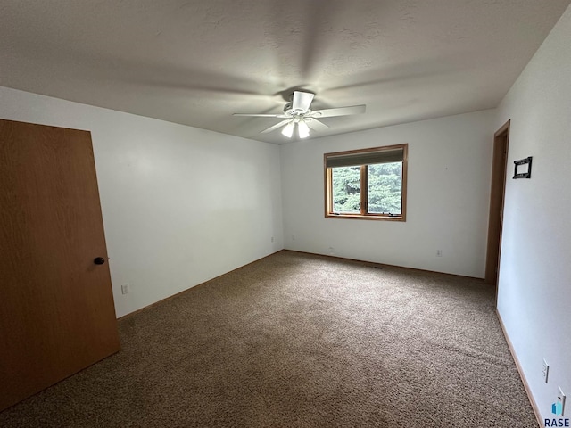 empty room featuring ceiling fan and carpet flooring