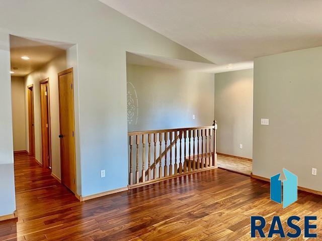 spare room featuring lofted ceiling and hardwood / wood-style floors