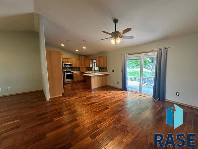 unfurnished living room with lofted ceiling, dark hardwood / wood-style floors, and ceiling fan