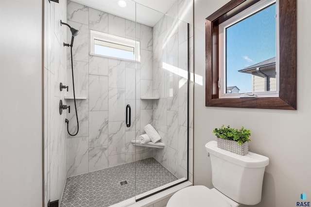 bathroom featuring toilet and a shower with door