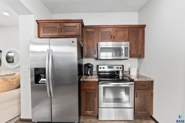 kitchen with light stone countertops and appliances with stainless steel finishes