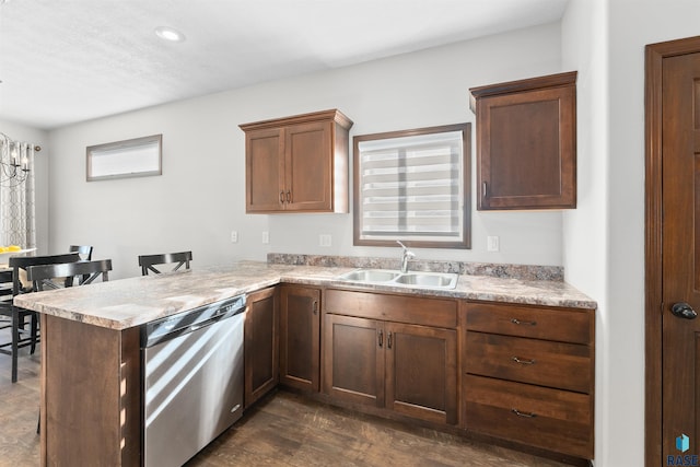 kitchen with sink, a breakfast bar, dishwasher, dark hardwood / wood-style flooring, and kitchen peninsula