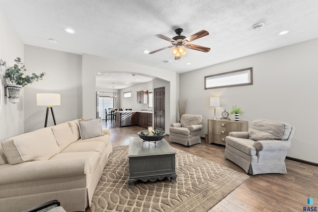 living room with hardwood / wood-style floors, a textured ceiling, and a notable chandelier