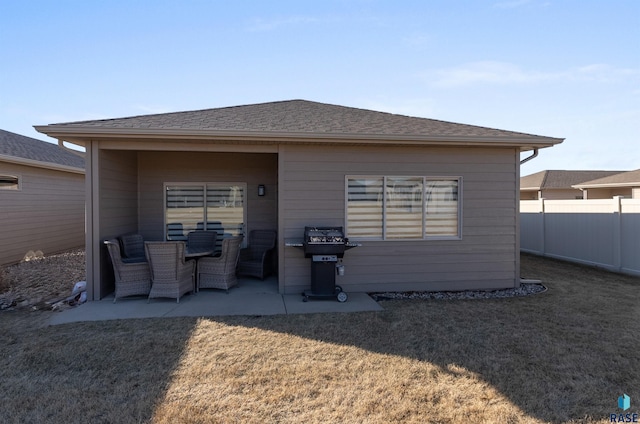 rear view of property featuring a patio and a yard