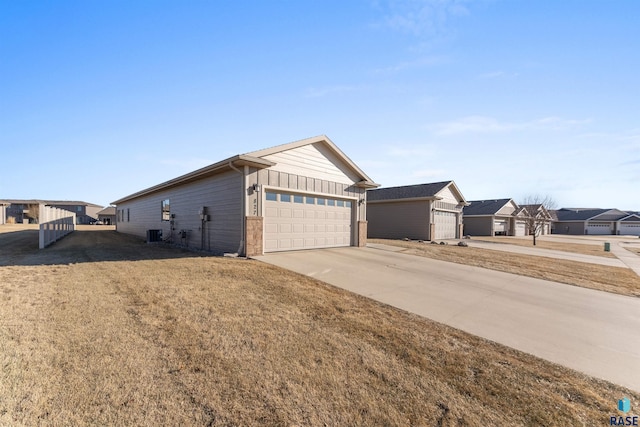 view of front of home featuring a garage, a front yard, and central air condition unit