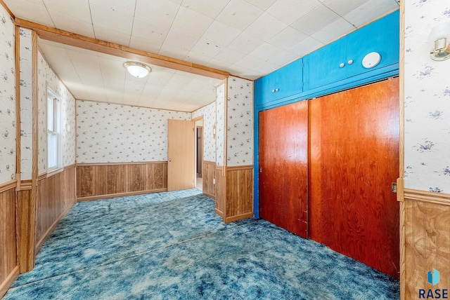 unfurnished room with dark carpet and wooden walls