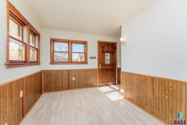 empty room featuring light hardwood / wood-style flooring and wood walls