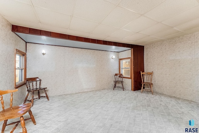 sitting room featuring a drop ceiling and carpet floors