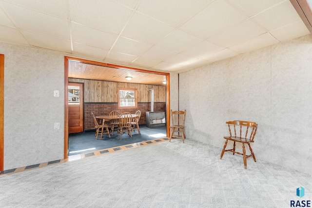 interior space featuring a wood stove and a drop ceiling