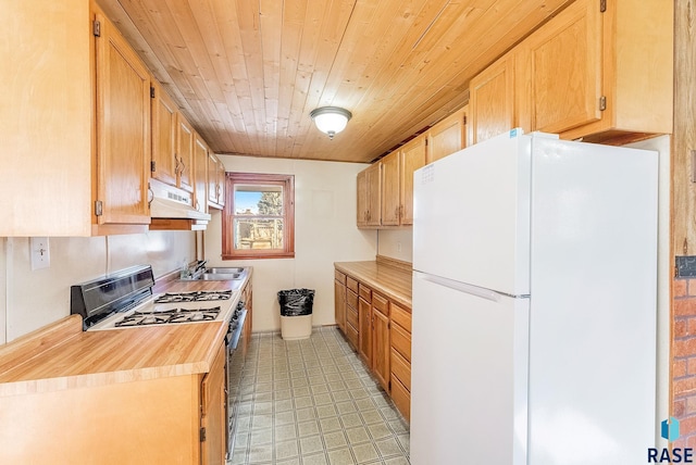 kitchen with gas range, white fridge, sink, and wooden ceiling