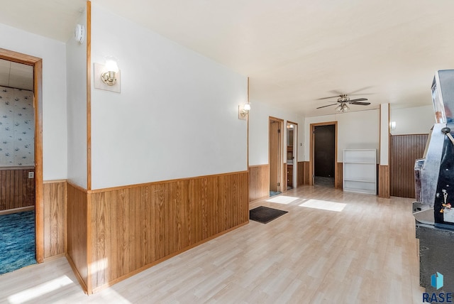 hall with light hardwood / wood-style floors and wood walls