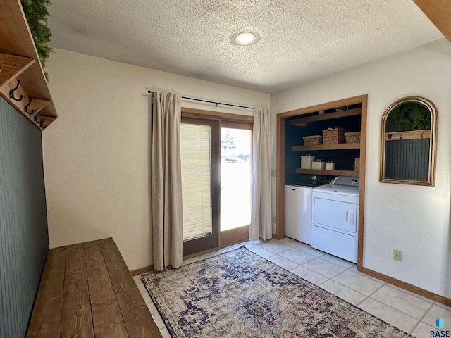 laundry room featuring light tile patterned floors, a textured ceiling, and independent washer and dryer