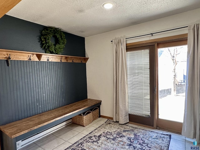 mudroom featuring a wealth of natural light, a textured ceiling, and light tile patterned flooring