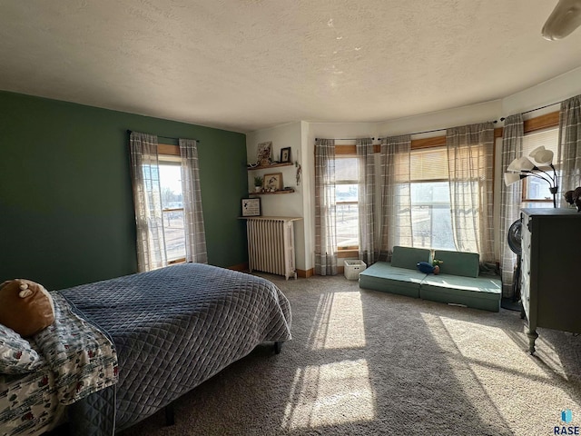 carpeted bedroom featuring radiator and a textured ceiling