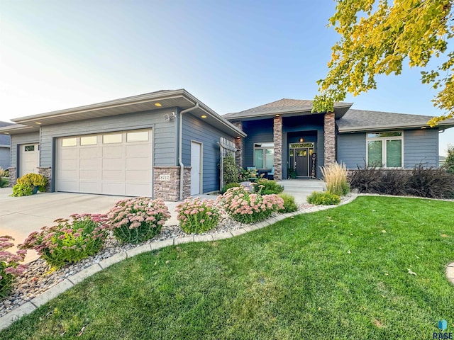 prairie-style home featuring a garage and a front yard