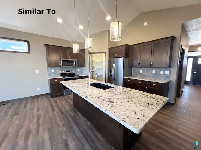 kitchen with decorative light fixtures, sink, stainless steel appliances, dark brown cabinets, and a center island with sink