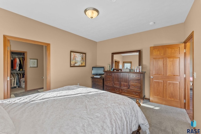 bedroom featuring a walk in closet and carpet floors