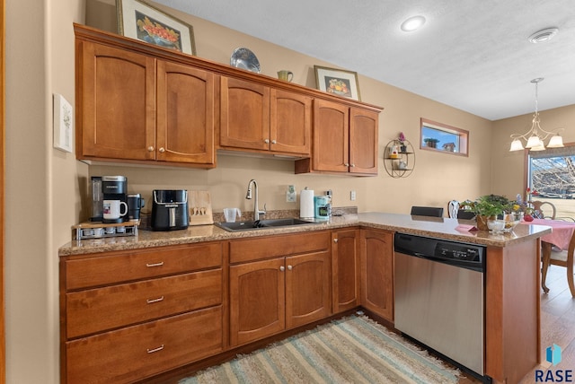 kitchen with sink, hanging light fixtures, a notable chandelier, stainless steel dishwasher, and kitchen peninsula