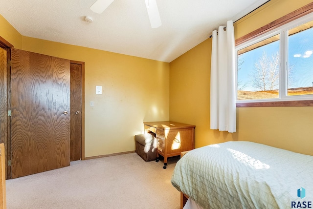 bedroom with ceiling fan, vaulted ceiling, and light carpet