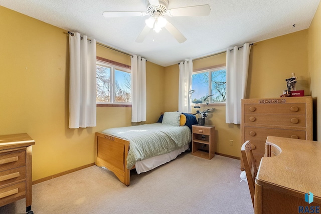 carpeted bedroom with multiple windows, a textured ceiling, and ceiling fan