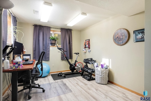 office with a textured ceiling and light wood-type flooring