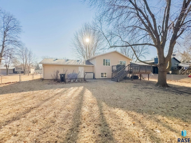 back of property with a lawn and a deck