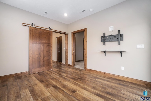 interior space featuring dark hardwood / wood-style flooring and a barn door