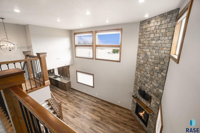 interior space featuring hardwood / wood-style floors, a large fireplace, and a chandelier