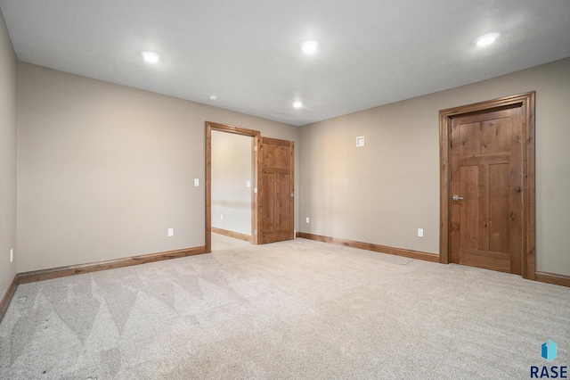 unfurnished bedroom featuring a walk in closet and light colored carpet